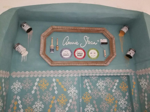 Renovácia steny. Starý premaľovaný rám, použité plechovky, štetce a logá farieb Annie Sloan.